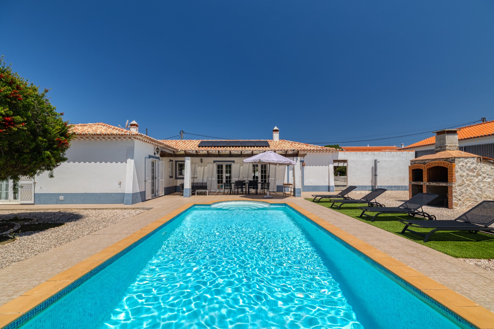 Long pool beside a whitewashed house